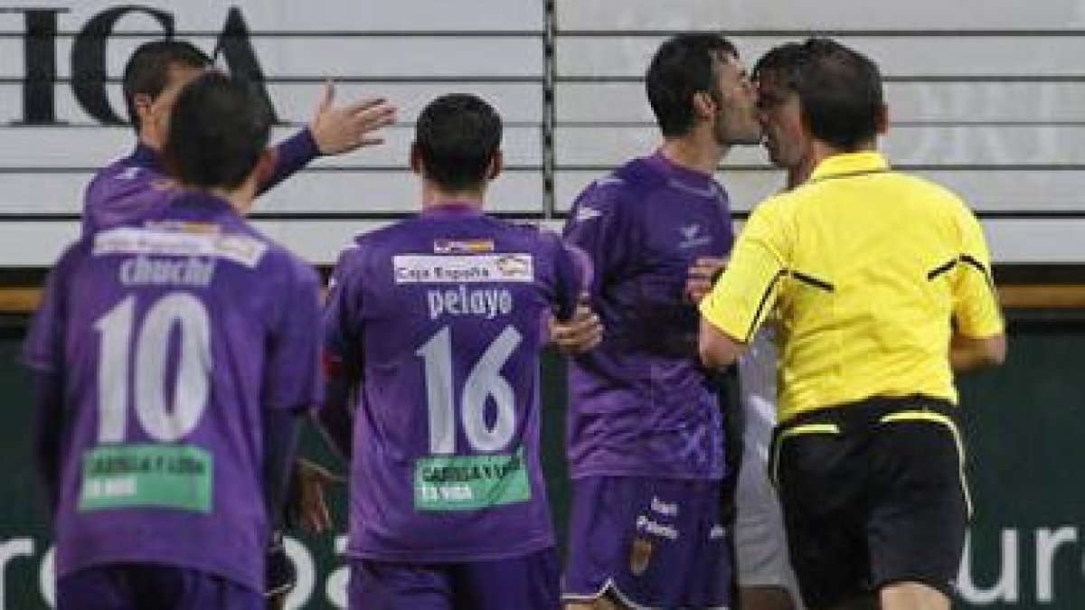 De Paula, a la derecha, agarra de la camiseta a Mena.