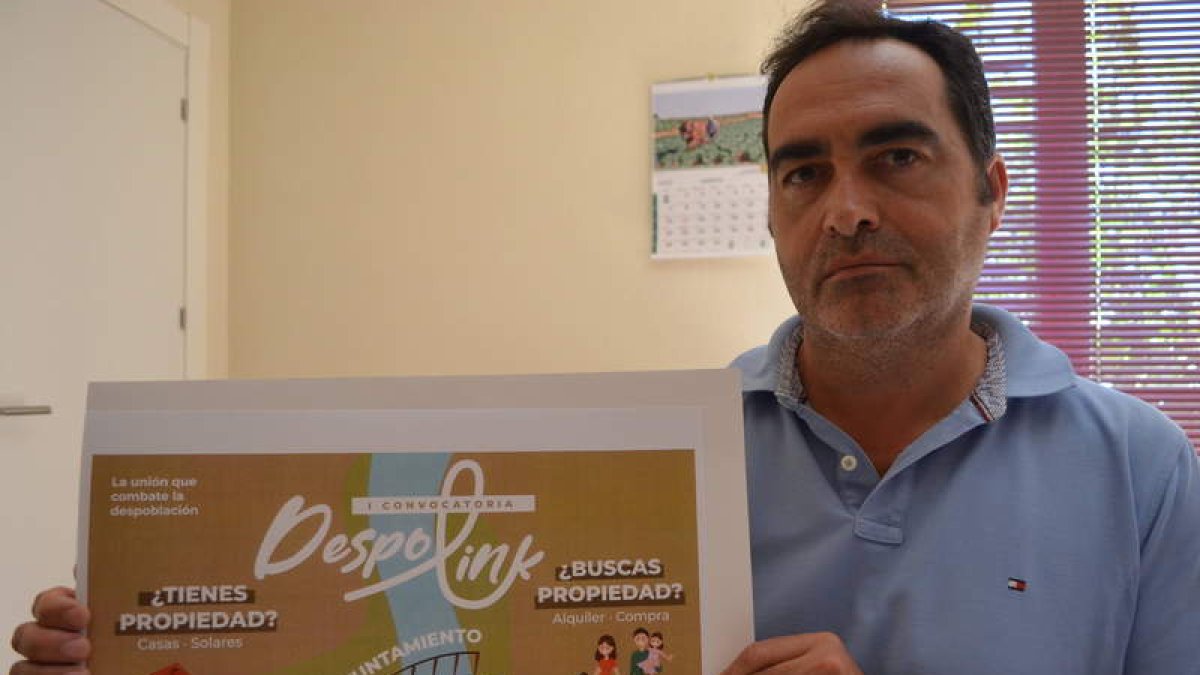 El alcalde de Fresno de la Vega, Alfonso Melón, muestra el cartel con la imagen de Despolink. MEDINA