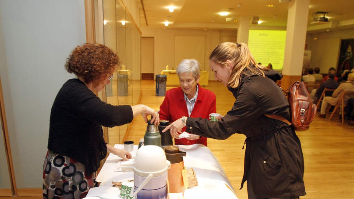 Voluntarios sirven un café a una ciudadana.