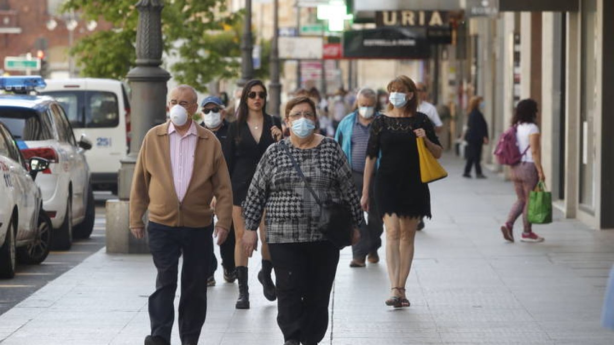 Gente transita por Ordoño II con las mascarillas de uso obligatorio.