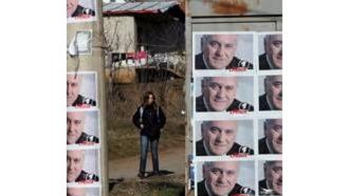 Una joven anda entre varios carteles electorales en apoyo de Nikolic