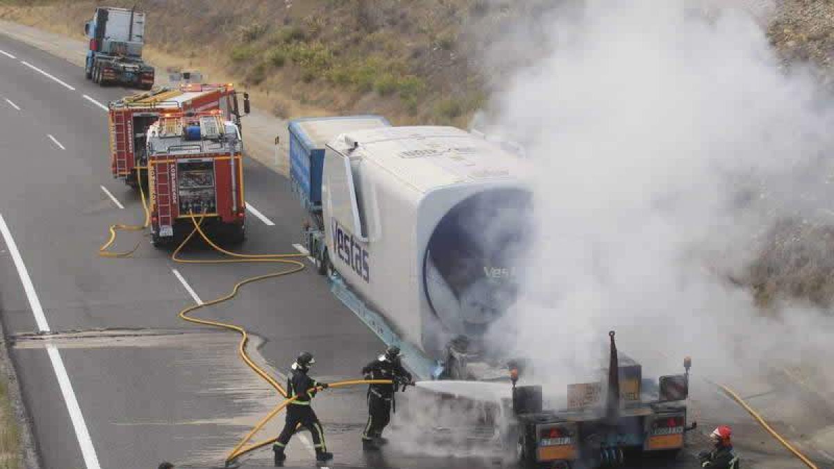 Los bomberos de Ponferrada,en plenas labores de extinción sobre la góndola en la A-6. l.