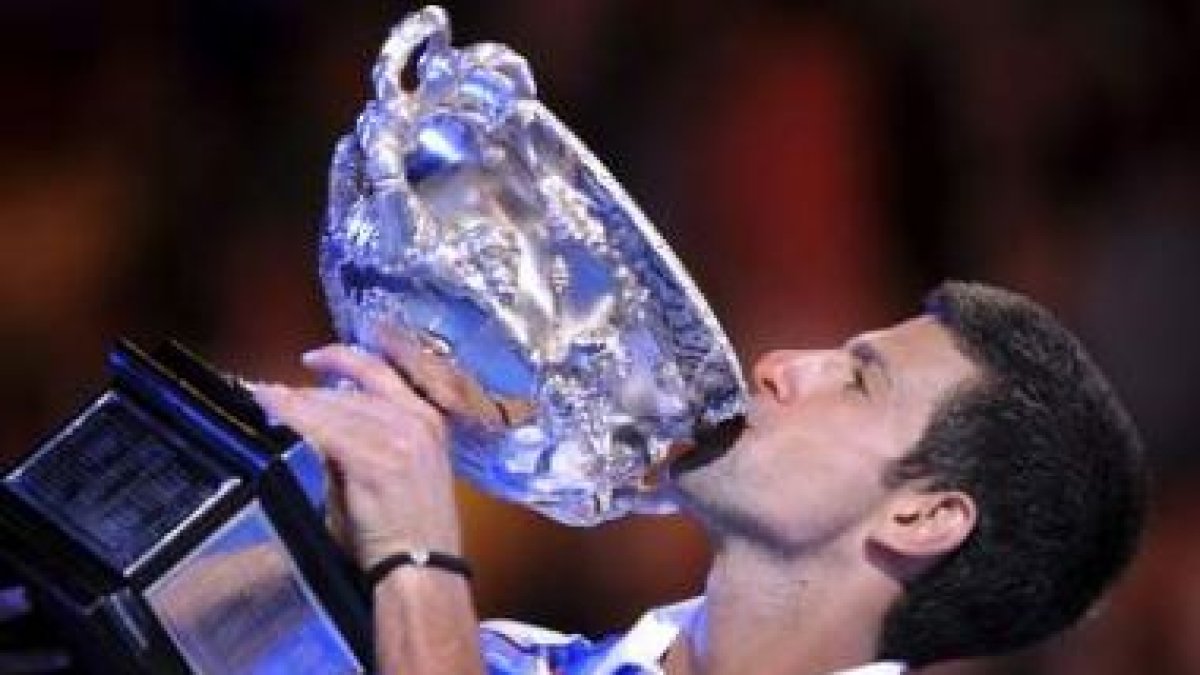 El serbio Djokovic besa su trofeo tras ganar a Murray en la final del Abierto de Australia.