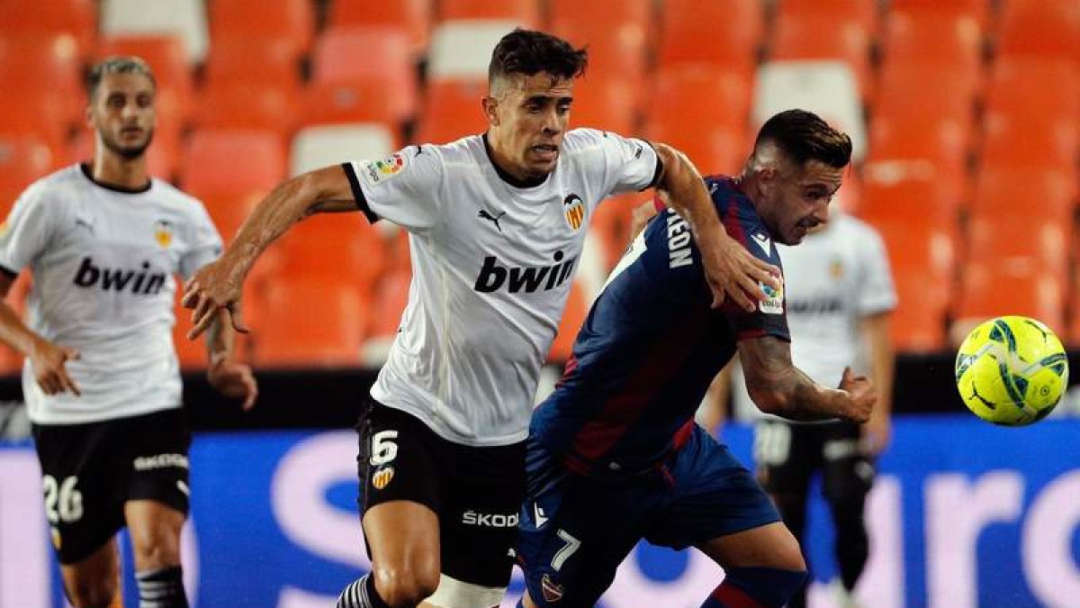 El brasileño Gabriel Paulista (i), del Valencia CF, lucha con Sergio León, del Levante. JUAN CARLOS CARDENAS