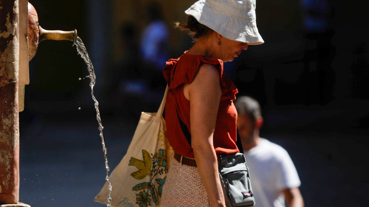 Una mujer pasa junto a una fuente. EFE/RAFA ALCAIDE