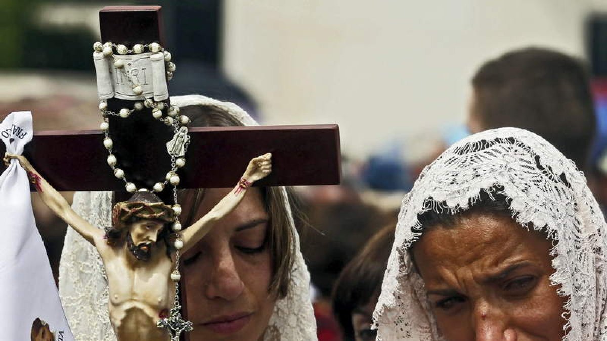 Dos devotas participan en la peregrinación anual hacia el santuario de Fátima.