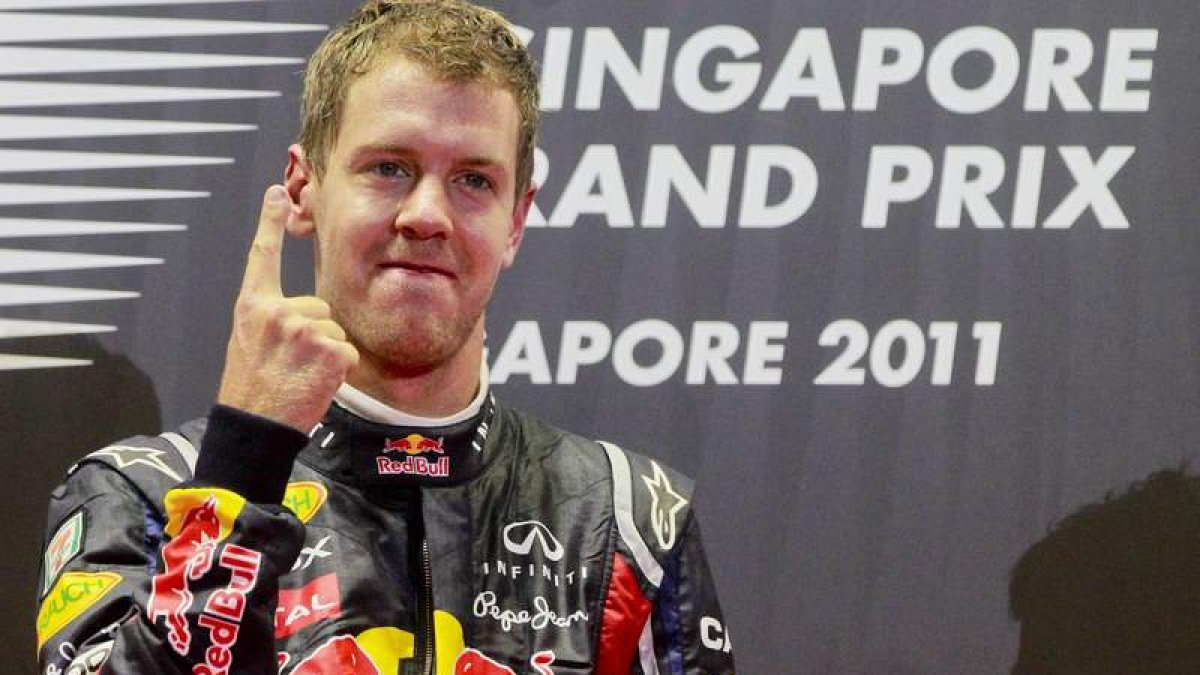 El piloto alemán de Fórmula Uno, Sebastian Vettel, indica en el podio con su índice que le hace falta un solo punto para proclamarse bicampeón mundial.
