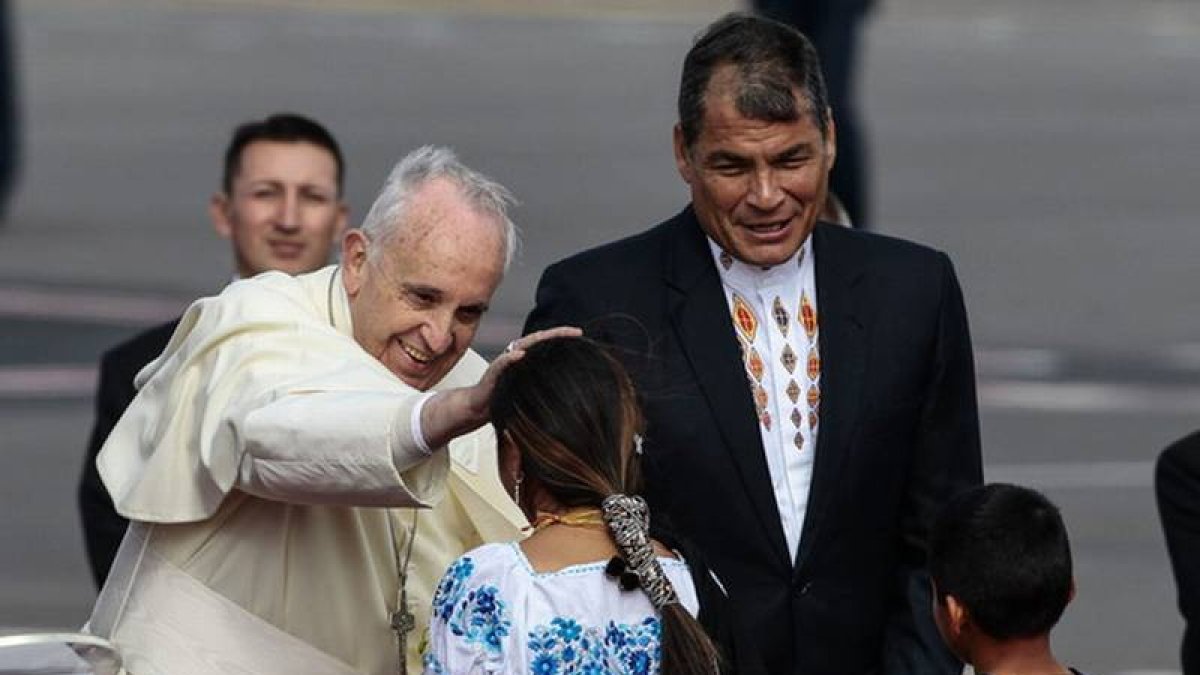 El Papa saluda a uns niños indígenas ante la mirada del presidente de Ecuador, Rafael Correa.