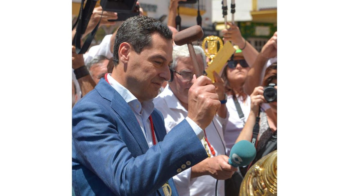 Juanma Moreno hace el toque de campana, ayer. ANTONIO PAZ