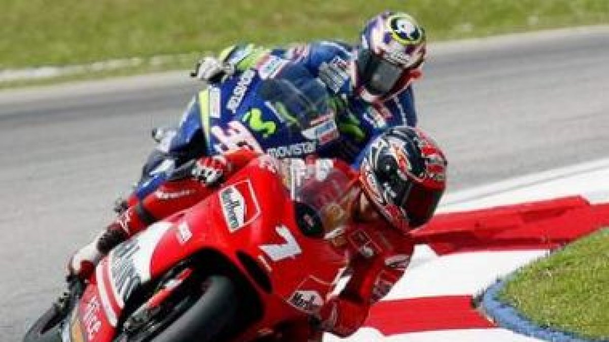 Carlos Checa, delante con su Ducati toma una curva seguido por Marco Melandri.