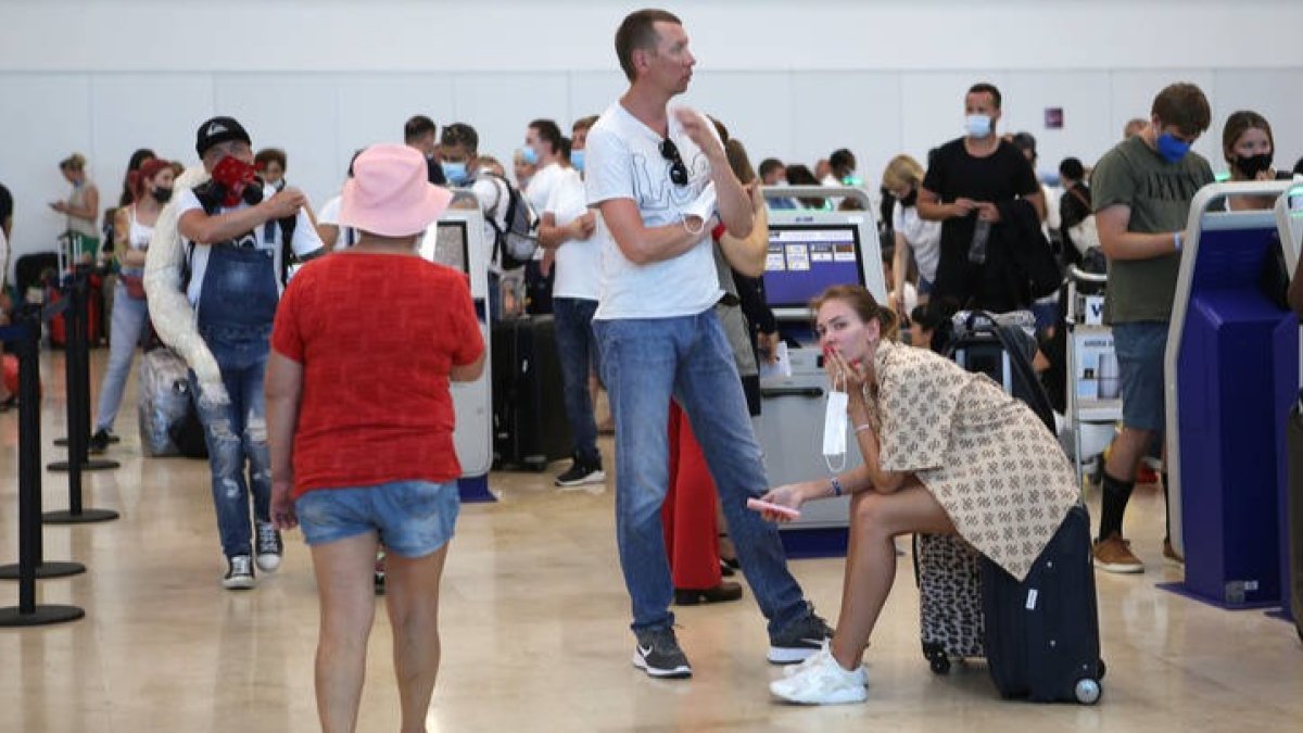 Turistas de origen ruso a la espera de abordar un avión de regreso a su país de origen en el aeropuerto internacional del balneario de Cancún. LOURDES CRUZ