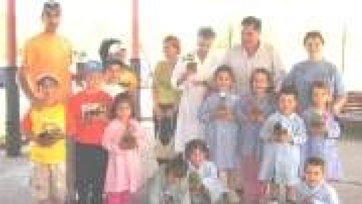 El alcalde junto a varios escolares a los que se entregó una planta