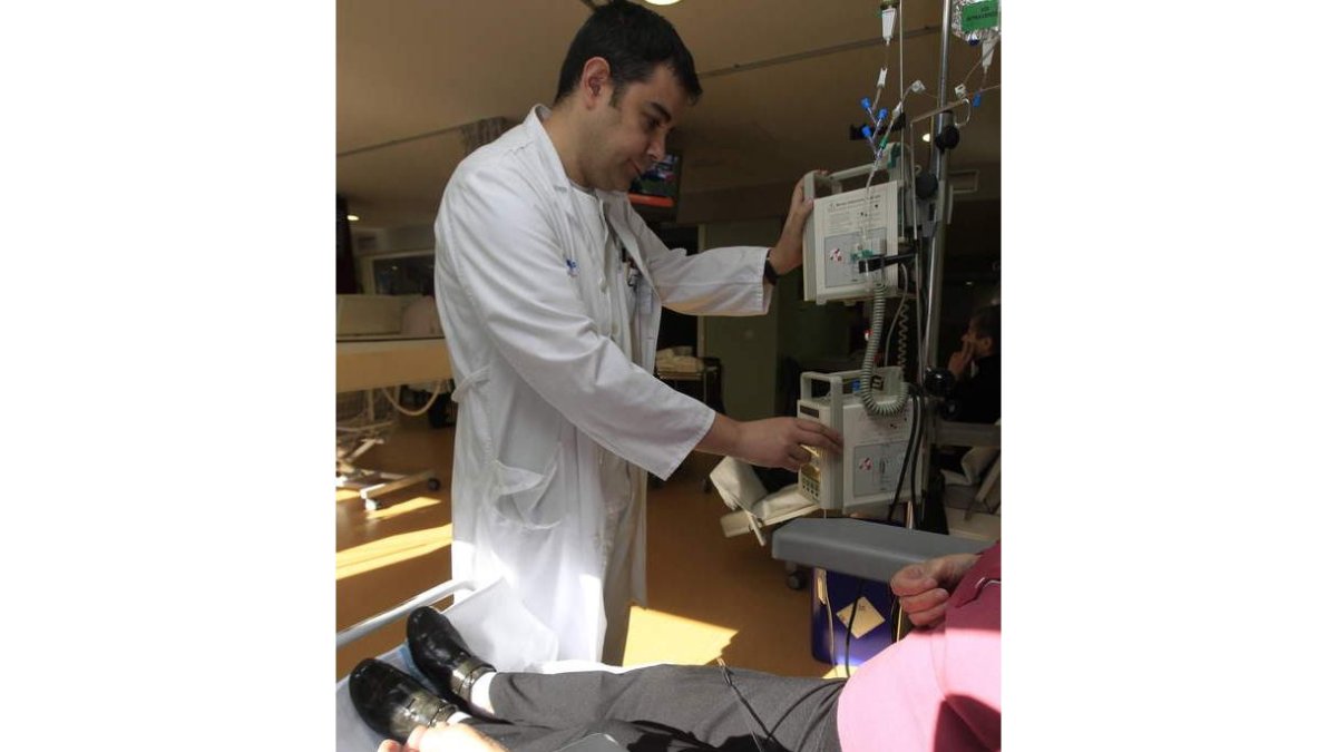 Un enfermero ajusta la dosis de citostáticos a una paciente en el Hospital de León.