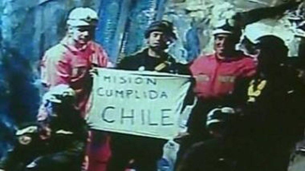El momento en que los rescatistas despliegan el cartel.