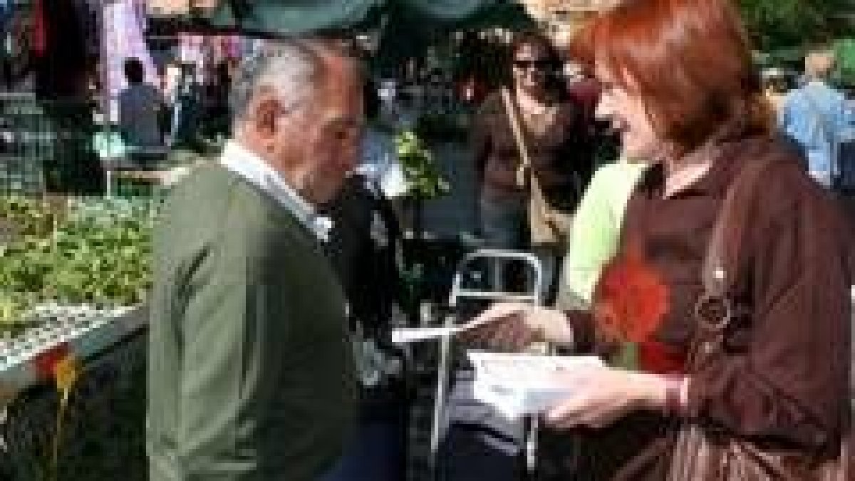 Miguel Martínez entrega un clavel y conversa con una mujer