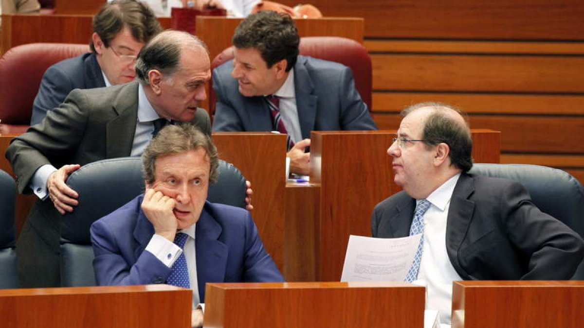 El presidente de la Junta, Juan Vicente Herrera, conversa con el consejero de Economía, Tomás Villanueva, durante la sesión.
