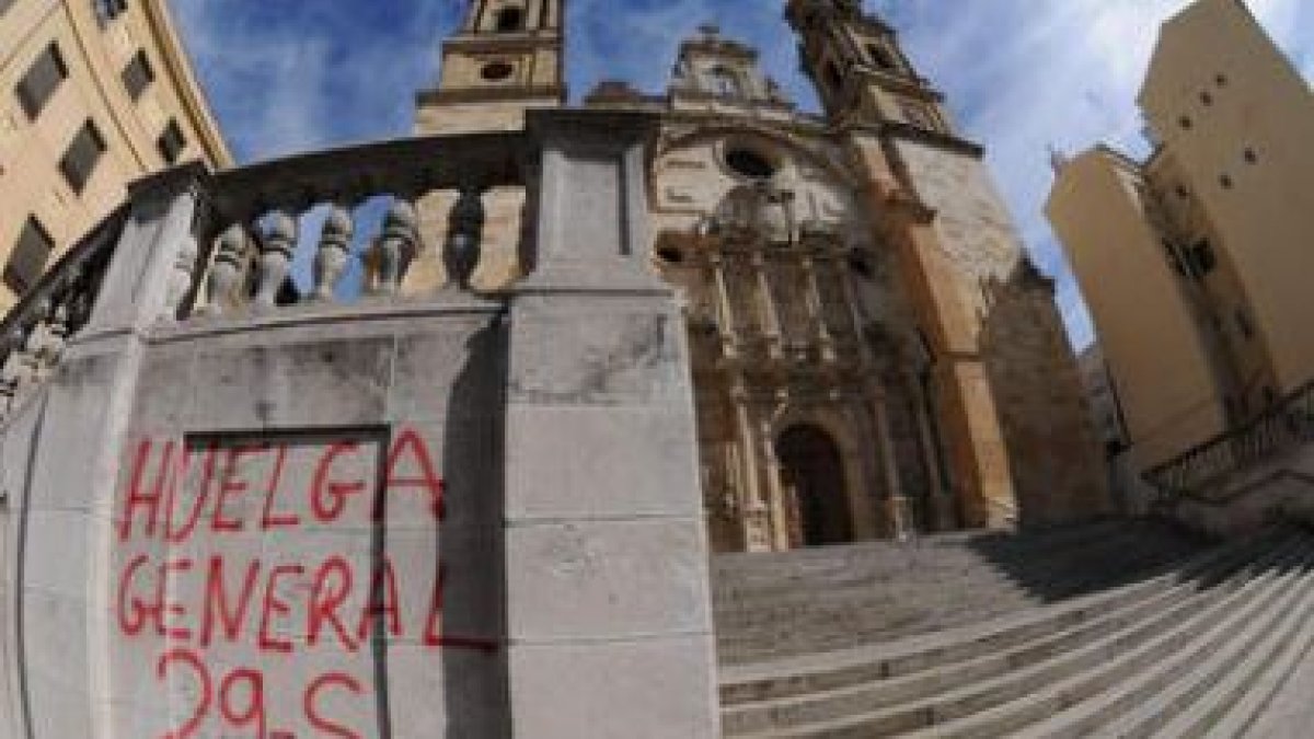 Una pintada llama a la huelga en los muros exteriores de la iglesia de San Juan y San Pedro