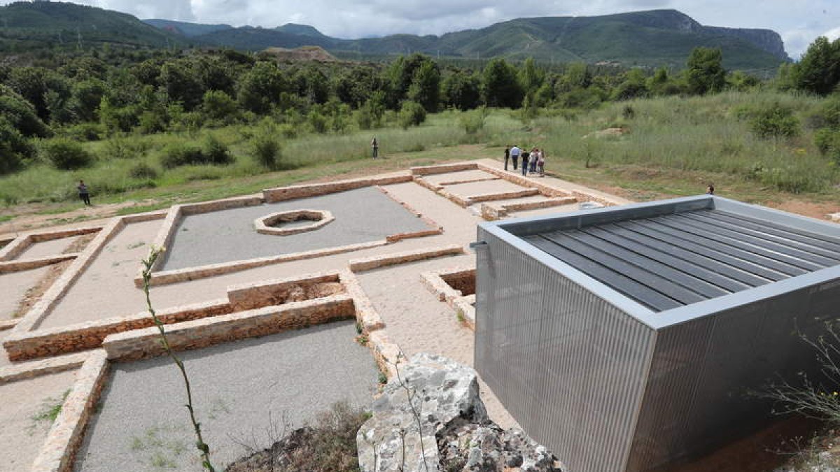 Cimentos de la domus, con el peristilo y el estanque octogonal. Derecha, estancia con pinturas protegida con una estructura. DE LA MATA