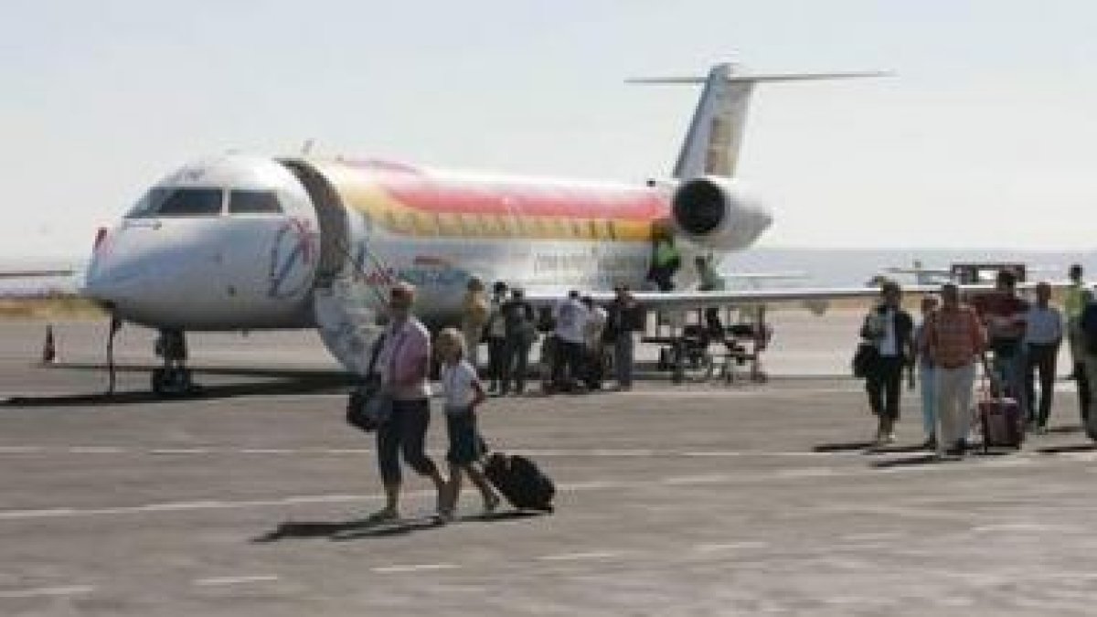Pasajeros en la pista del aeropuerto tras el aterrizaje.