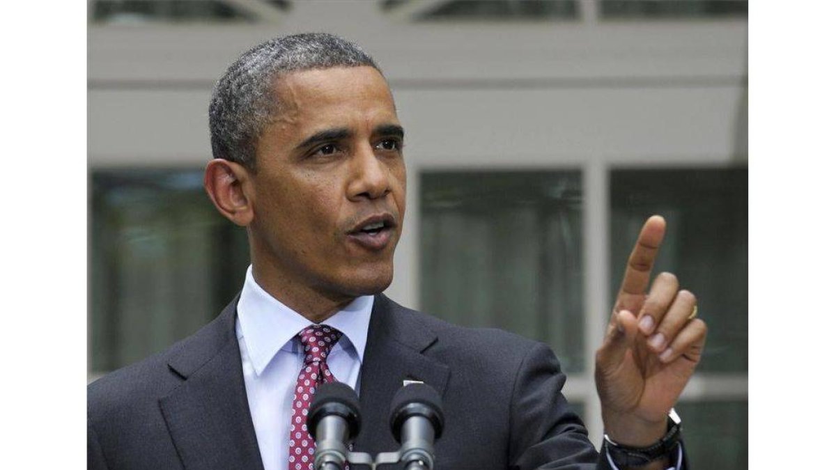 Obama, junto a su mujer e hijas, saluda en un mitin.