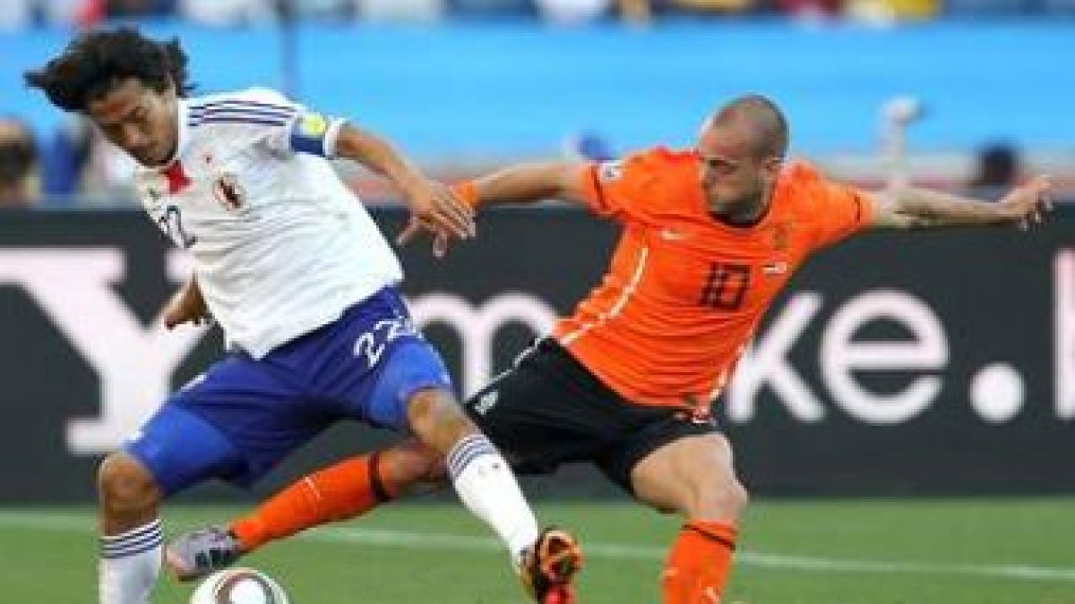 Sneijder (d) disputa el balón al japonés Yuji Nakazawa.