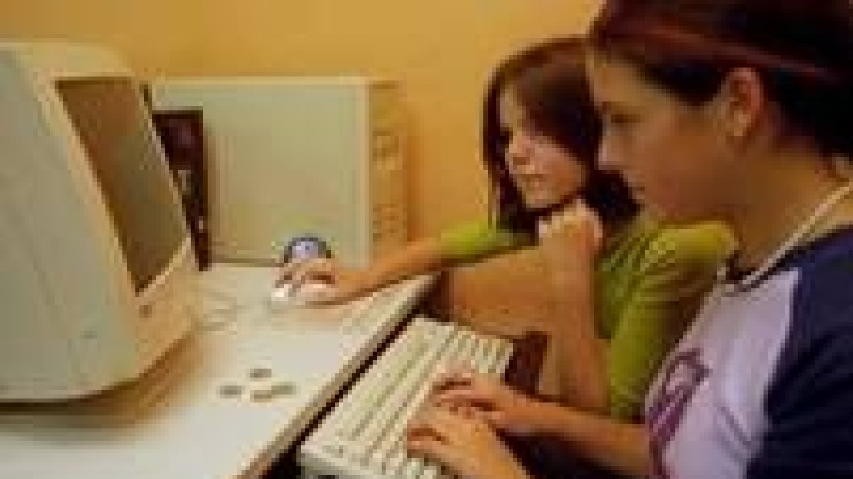Dos jóvenes, navegando por Internet en un ciber de León