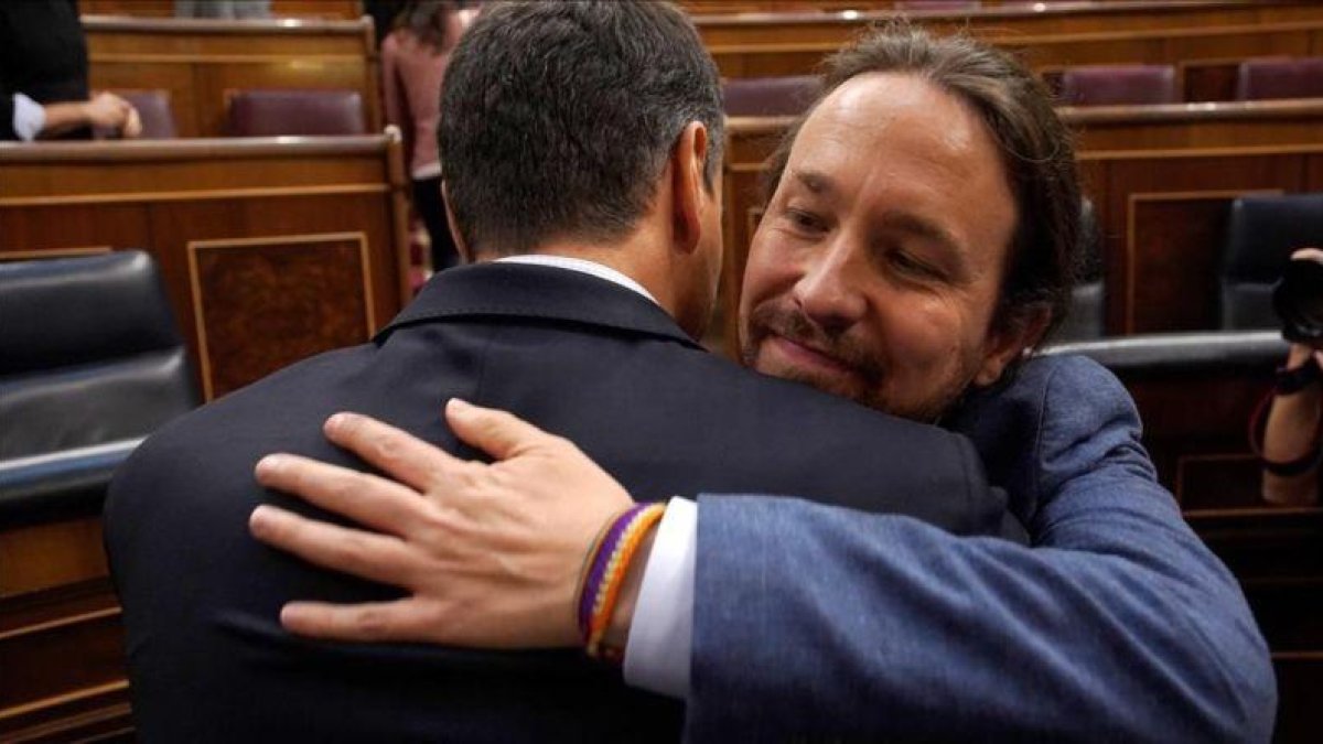 Pablo Iglesias abraza a Pedro Sánchez tras la votación de la moción de censura en el Congreso.