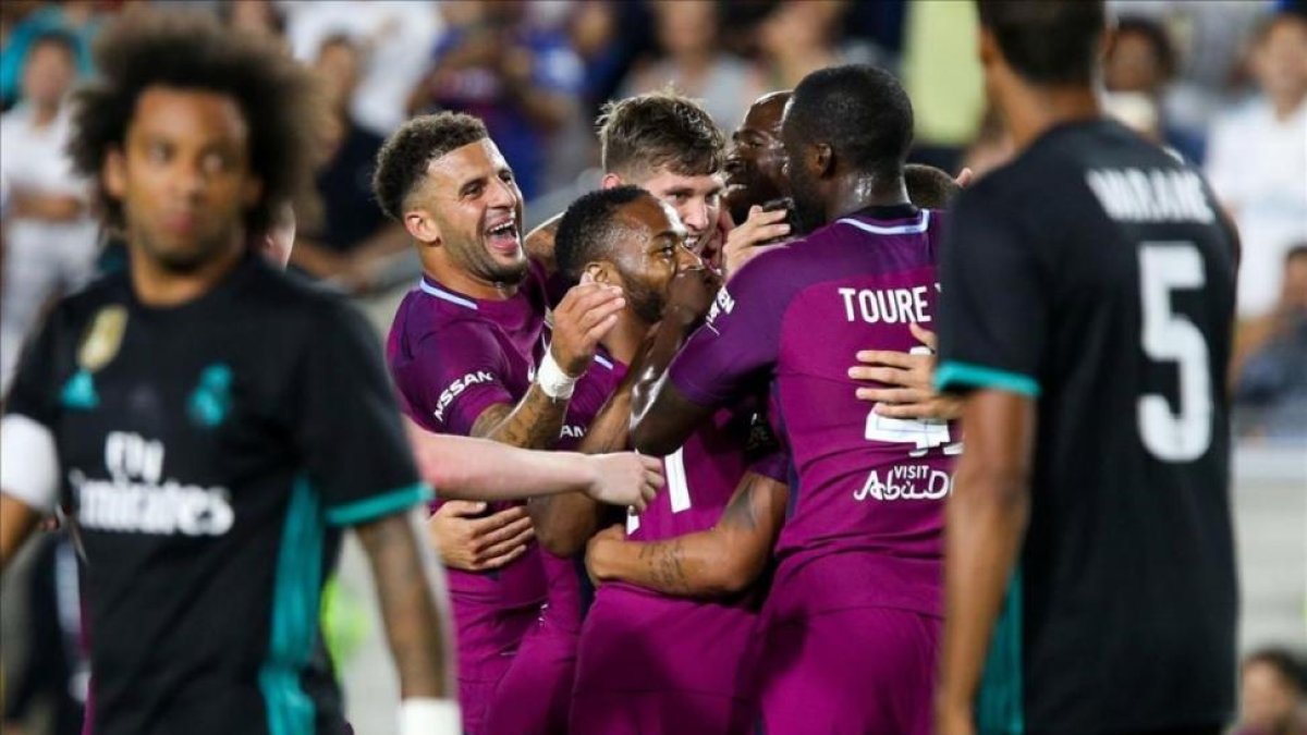 Los jugadores del City celebran un gol ante la mirada de Marcelo y Varane.
