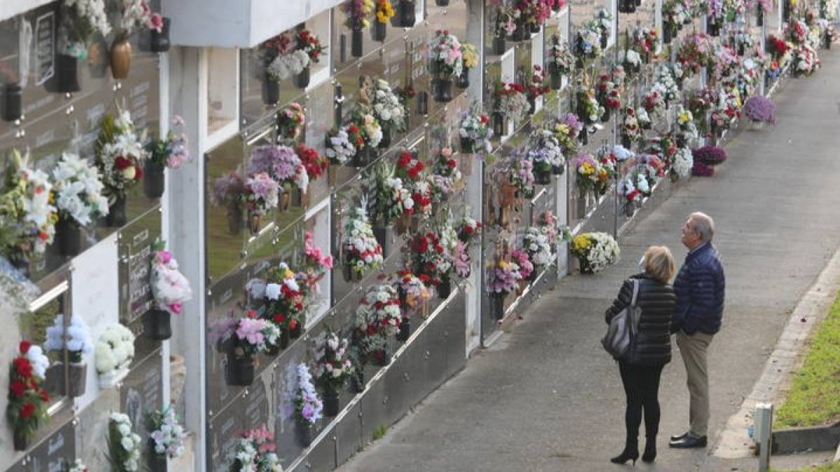 Dos personas junto al nicho familiar en el cementerio de Ponferrada. L. DE LA MATA