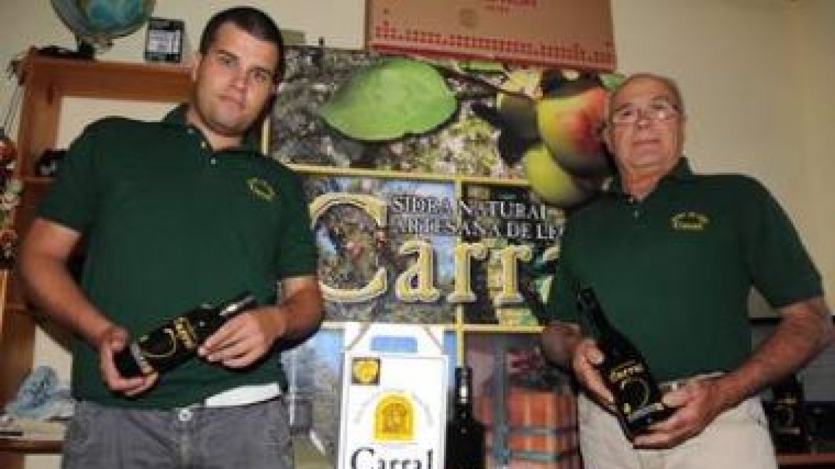 Herminio Carral y su hijo con lasidra embotellada que producenen Santa Maríadel Condado.