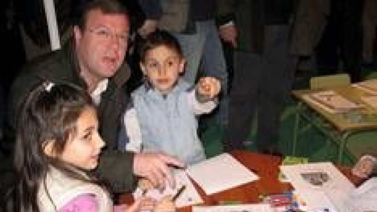 Unos niños enseñan a Silván los dibujos que realizan de animales