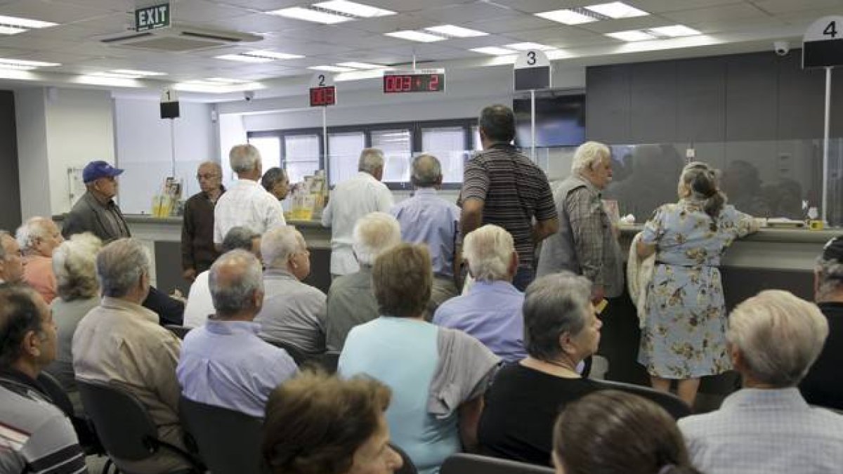 La gente espera en el interior de un banco en Atenas.