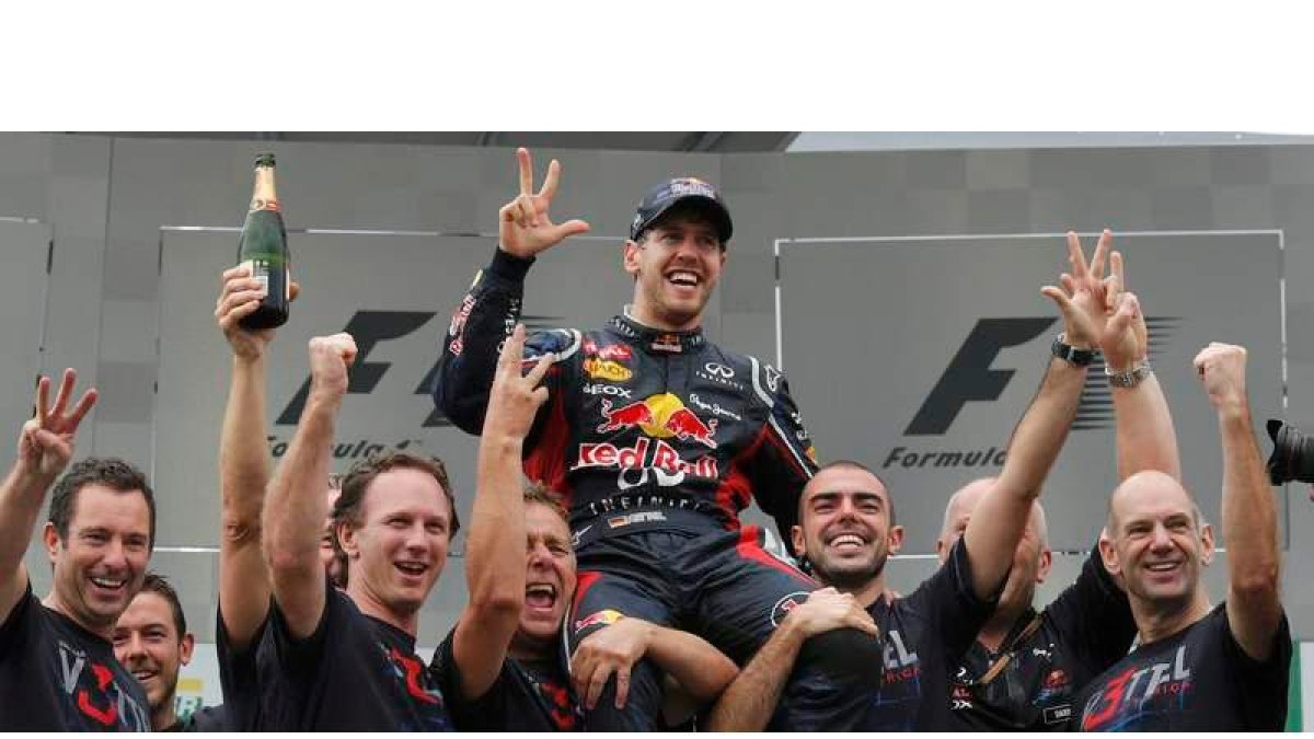 Vettel celebra con los integrantes de su escudería, incluido el director Chris Horner y el ingeniero jefe Adrian Newey, su tercer título de campeón de Fórmula 1.