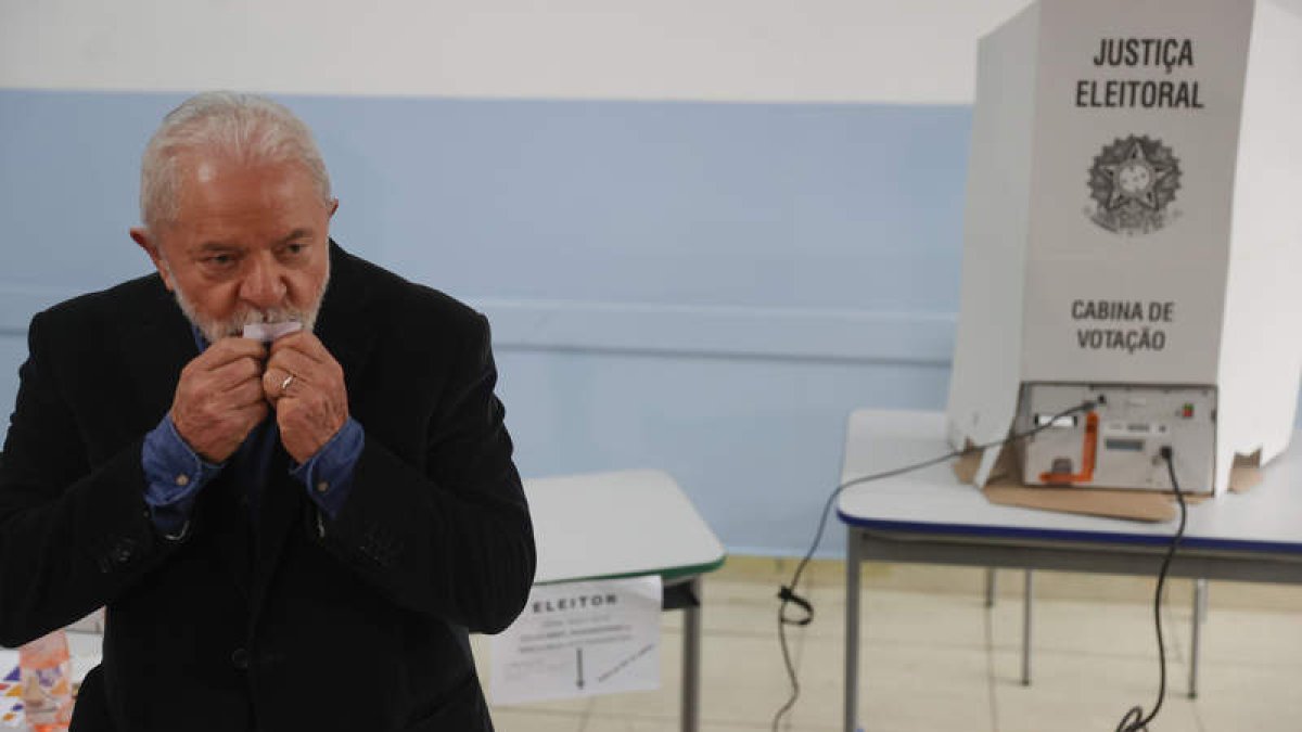 Lula besa la papeleta ayer, en el colegio donde votó. FERNANDO BIZERRA
