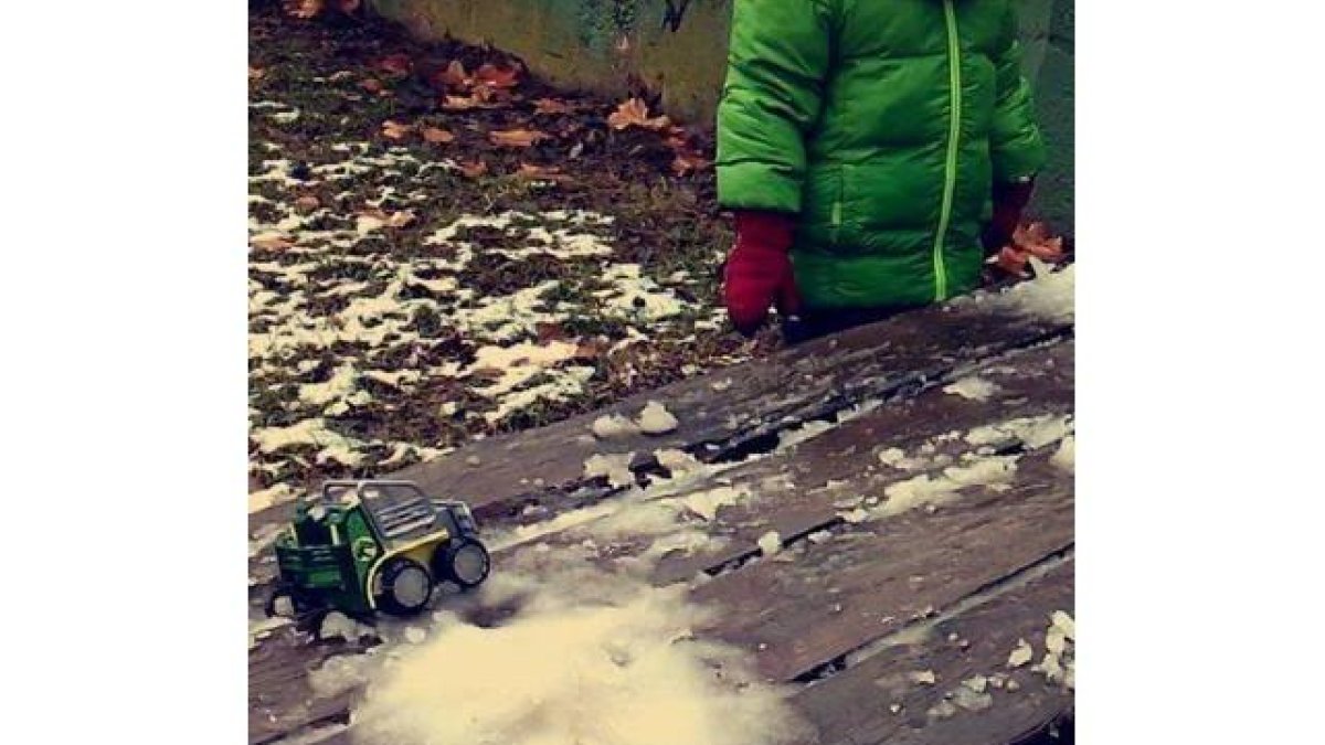 Una niña juega con un camión y la nieve en la zona peatonal del Bernesga
