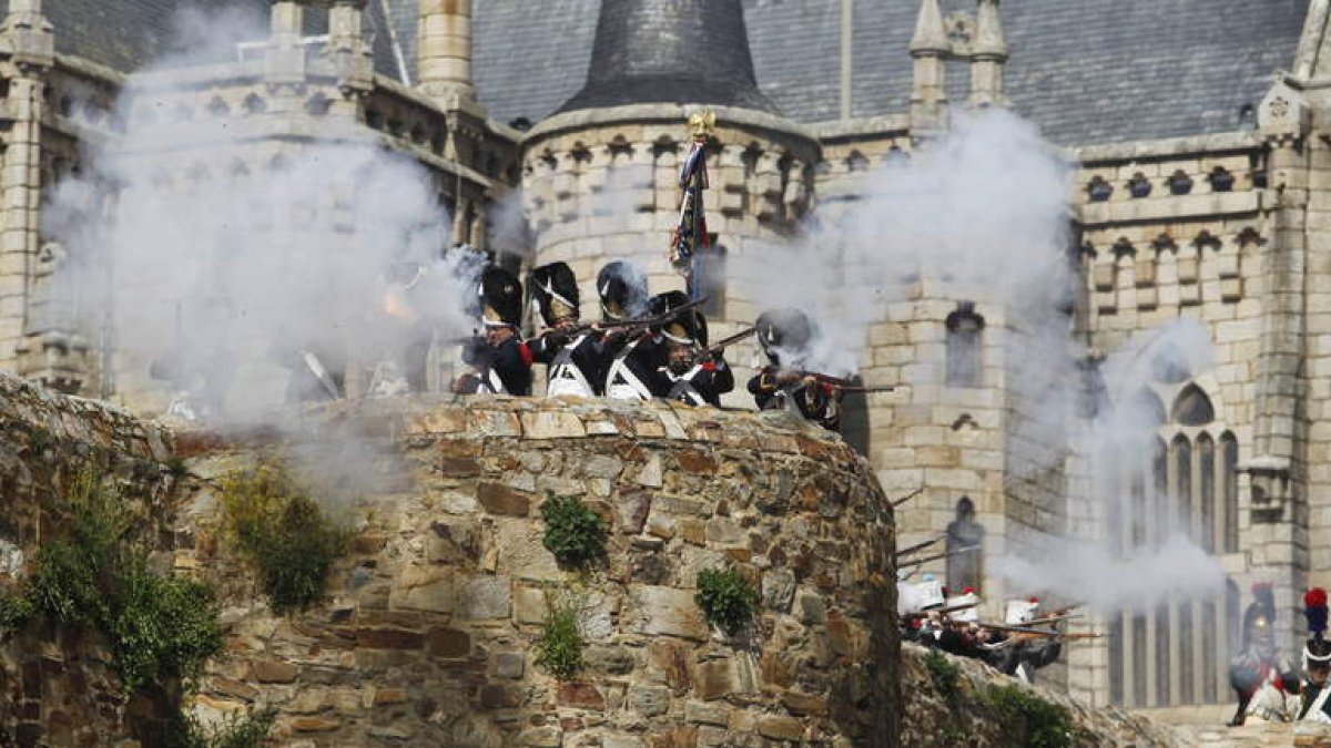 Soldados franceses tratan de rechazar el avance de los españoles con disparos de fusil desde lo alto de la muralla.