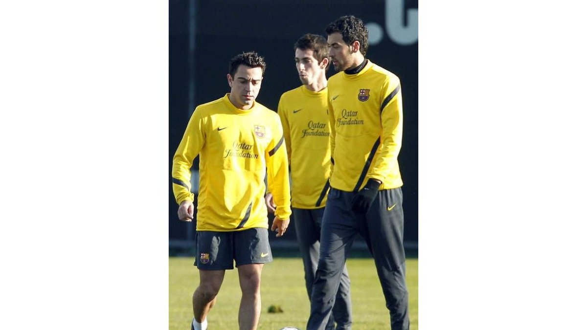 Xavi, Cuenca y Busquets, durante el entrenamiento del Barça.