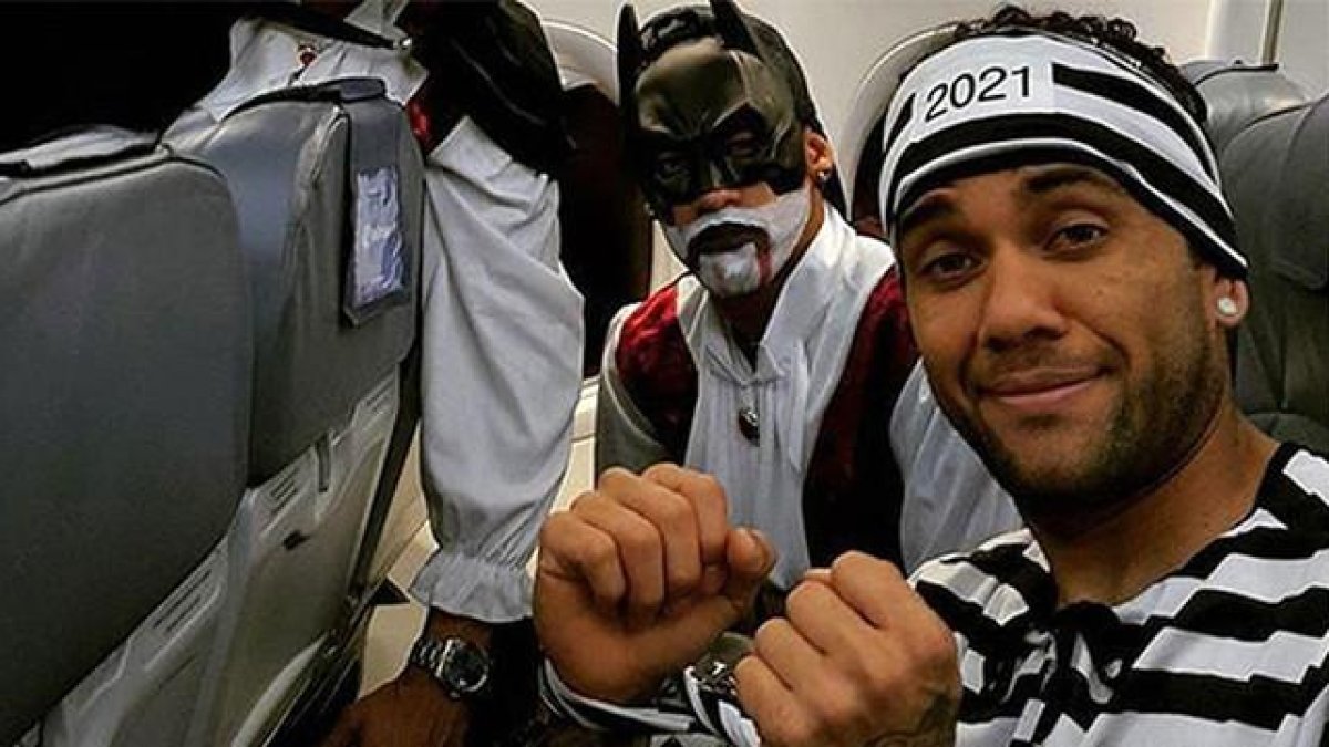 Alves, vestido de presidiario, junto a Suárez, con un disfraz de Batman, en el avión de regreso a Barcelona.