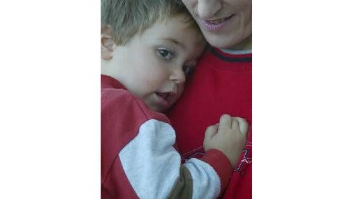 Iván, el último niño nacido en Escobar de Campos, en los brazos de su madre