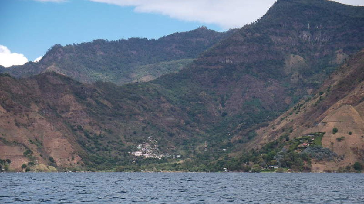 Una docena de pueblos se asientan sobre las laderas de este lago sagrado (arriba). “La curación”, uno de los murales que pueden contemplarse a lo largo del recorrido (centro). El sombrero y el pantalón bordado y colorista es aún una de las señ