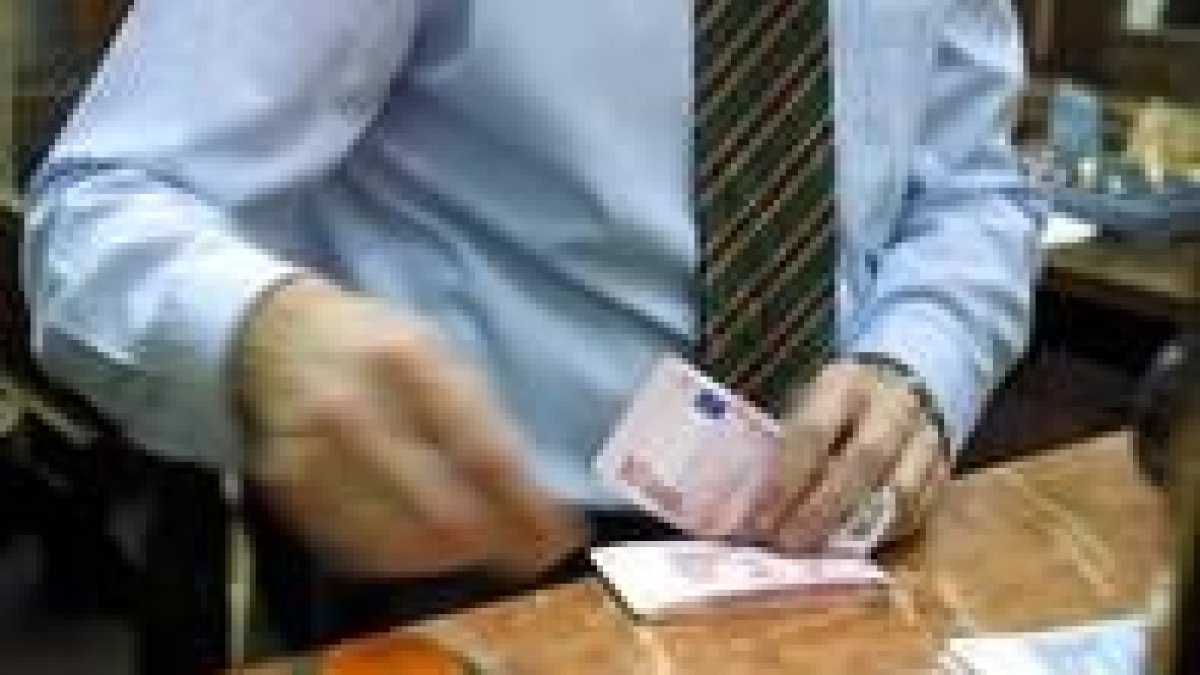 Un empleado de banca leonesa recoge el dinero de un cliente