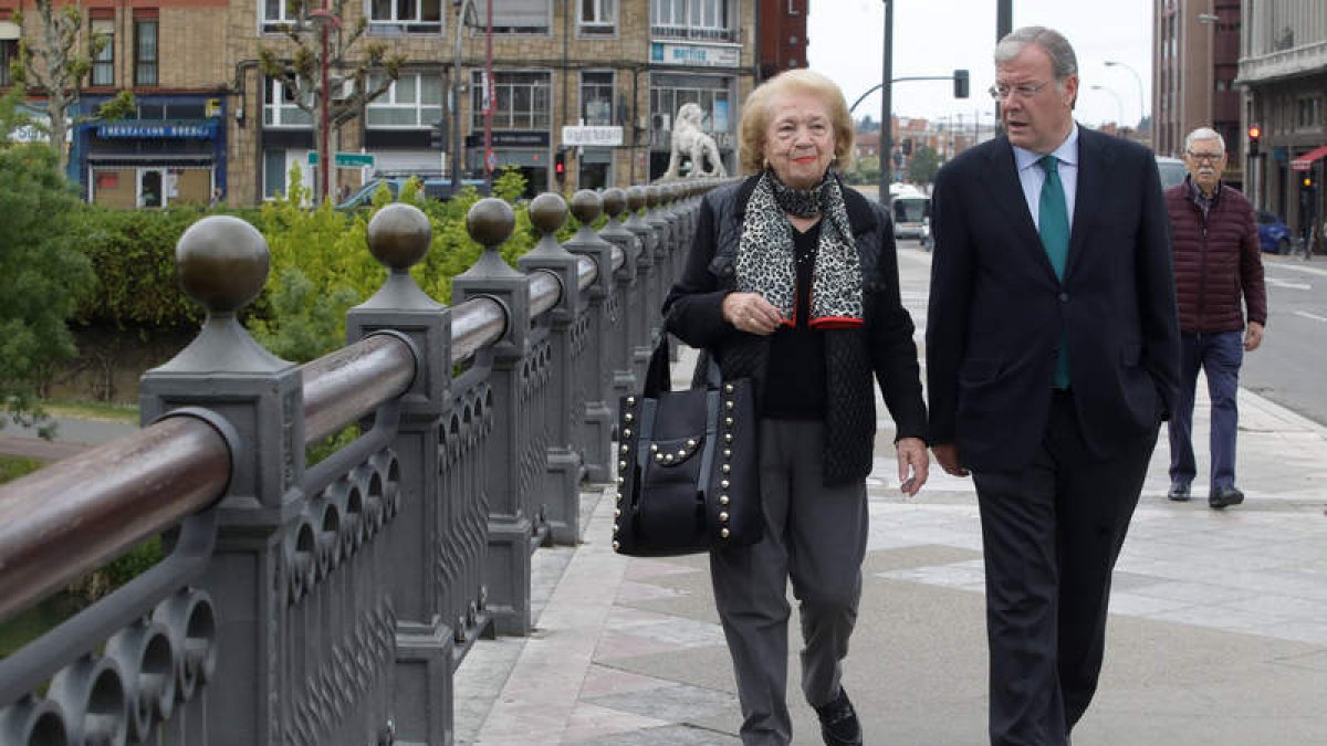 El candidato del PP, Antonio Silván, en el paseo diario con su madre, María Teresa Rodríguez, por el puente de los leones. RAMIRO