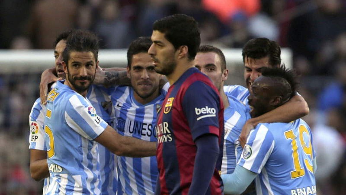 Los jugadores del Málaga celebran en gol de Juamni ante el gesto contrariado de Luis Suárez.