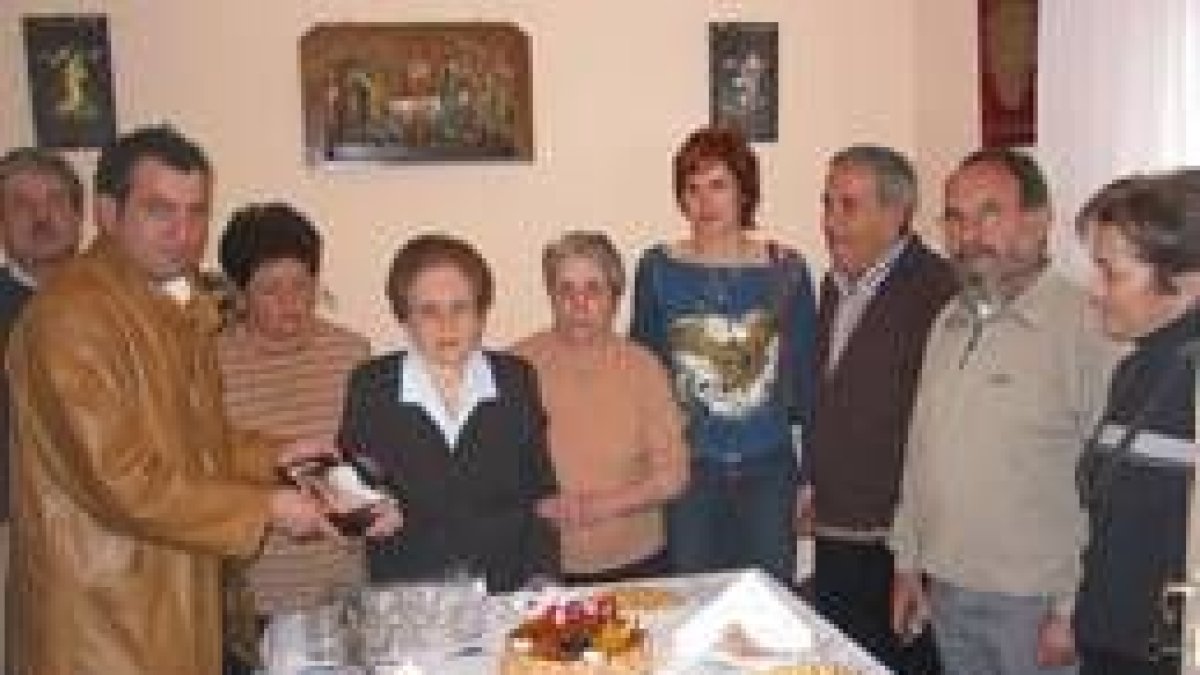 Nicanor Sen, alcalde de Cistierna, entrega una placa a la centenaria Piedad Pérez