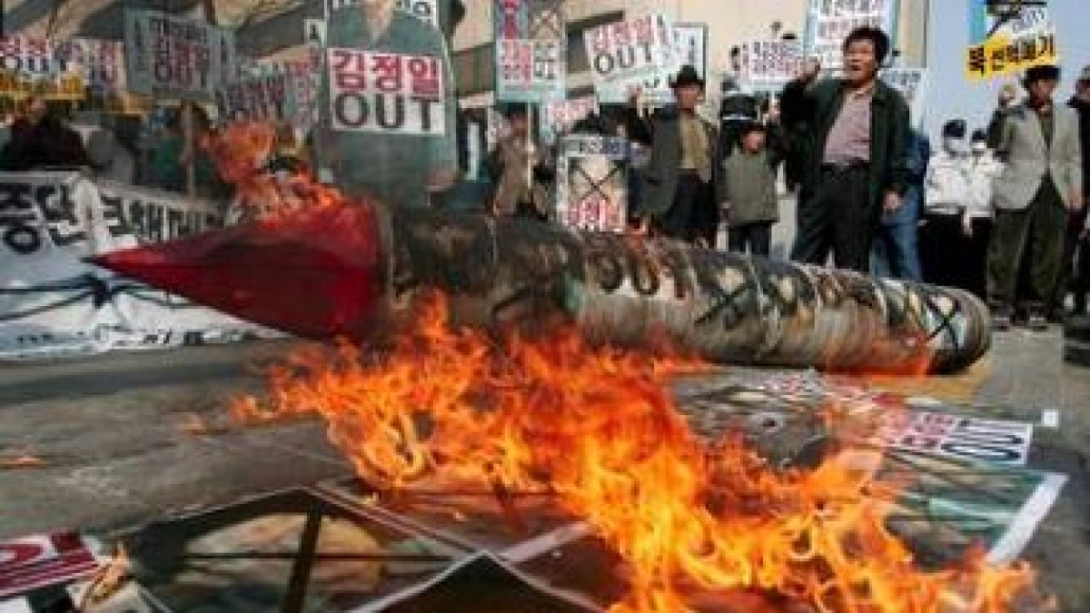 Varios manifestantes queman fotos del líder norcoreano en Seúl tras el lanzamiento del cohete