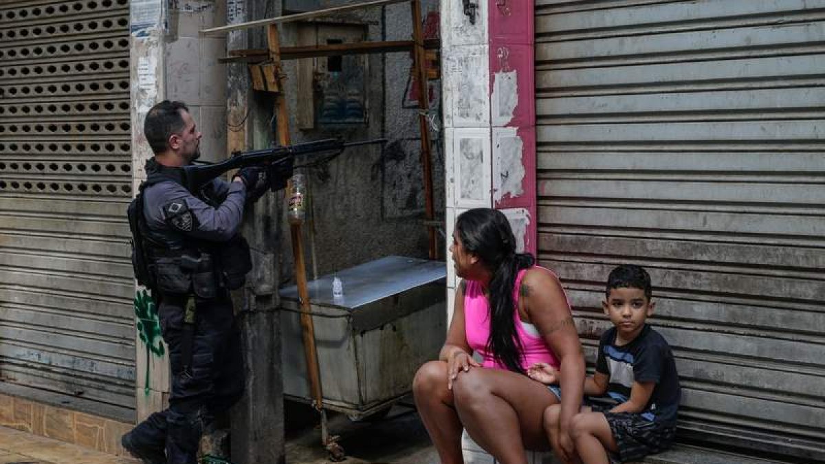 Una mujer y un niño contemplan la operación en la favela. ANDRÉ COELHO
