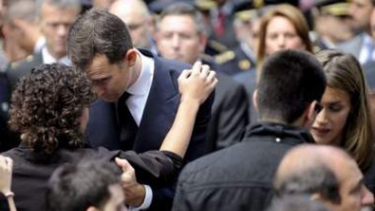 Los Príncipes de Asturias consuelan a los hijos del inspector Eduardo Puelles.