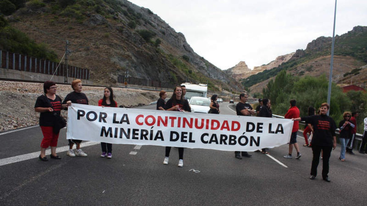 Un grupo de mujeres sostiene una pancarta mientras avanza por la N-630.