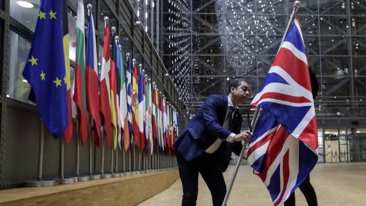Funcionarios ingleses retiran la bandera de su país en la sede del Consejo Europeo.