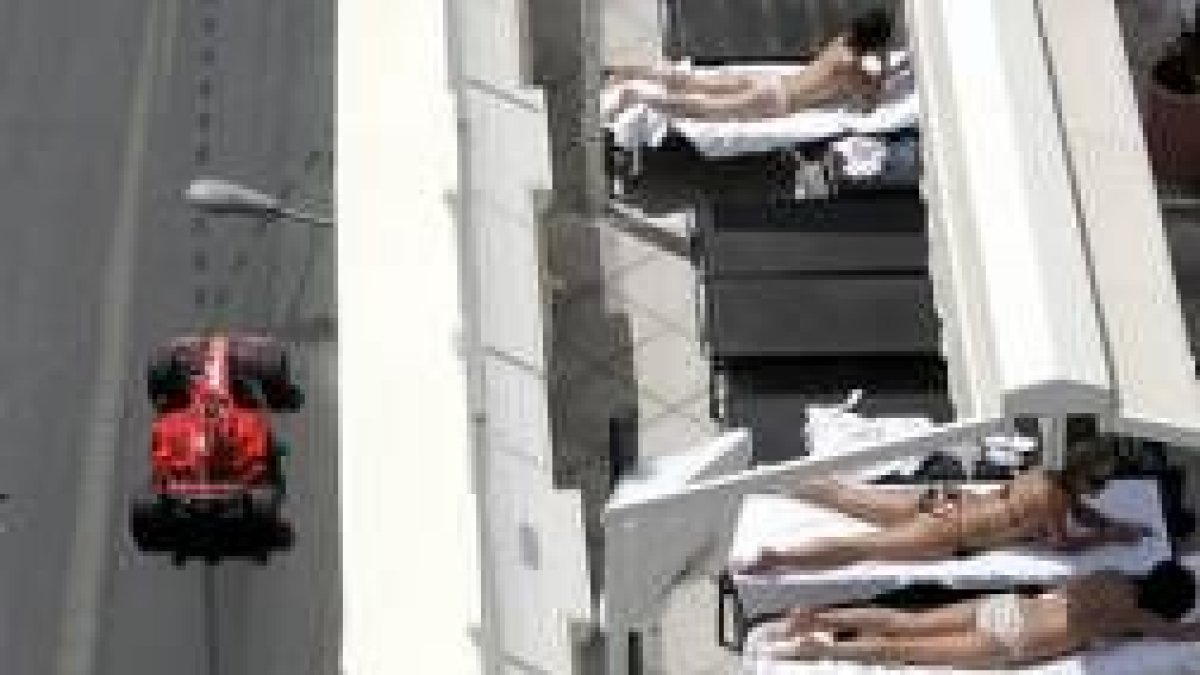 Un grupo de chicas toma el sol en una terraza de Mónaco mientras pasa un Ferrari
